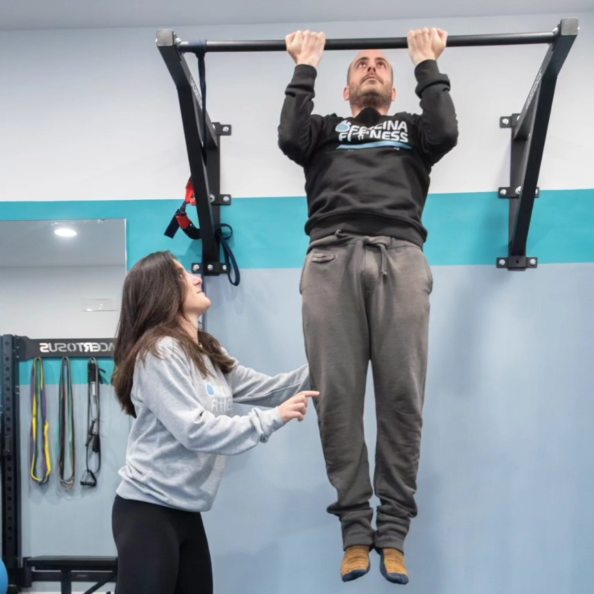 Allenamento assistito alla sbarra per trazioni con la personal trainer