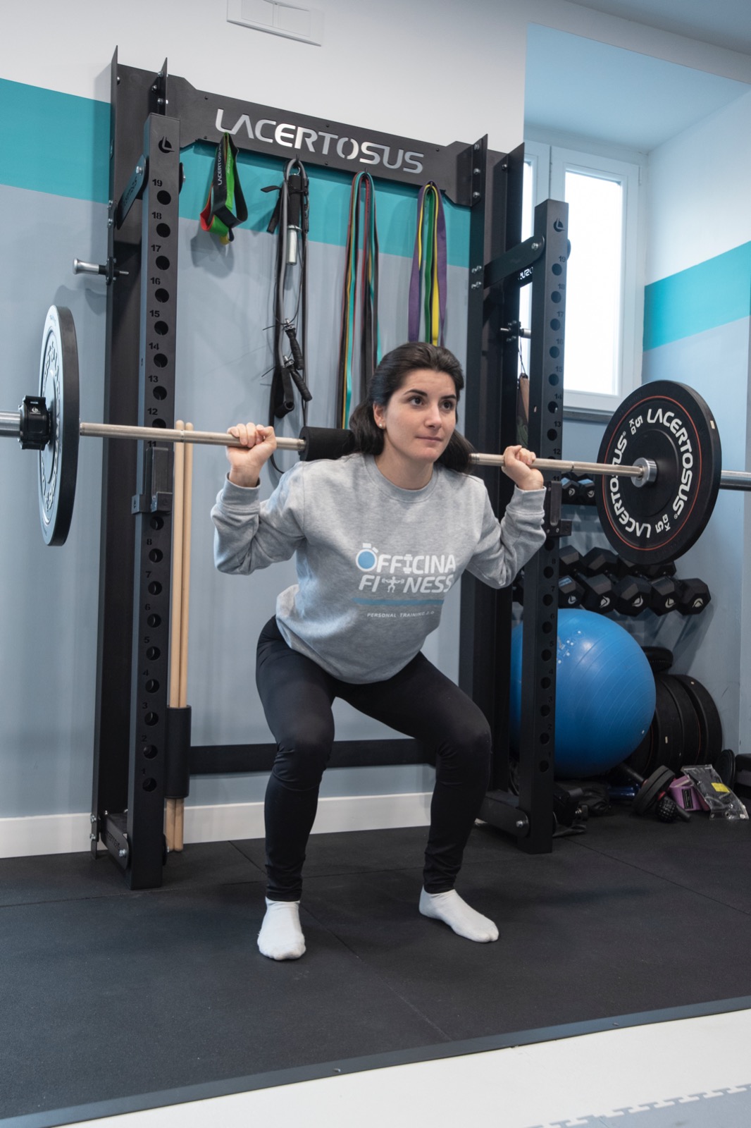 Esecuzione dello squat al rack Lacertosus nella sala attrezzi di Officina Fitness